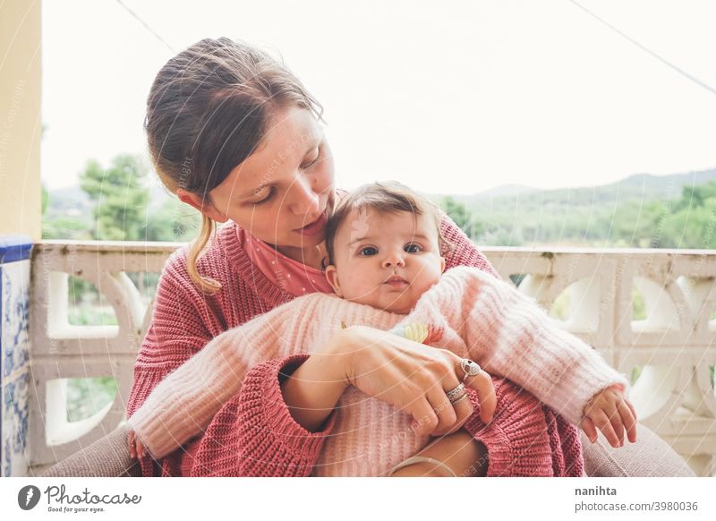 Young mother hugging her baby mom family motherhood happiness parenthood love lifestyle family time care lovely adorable cute real real people face pink home