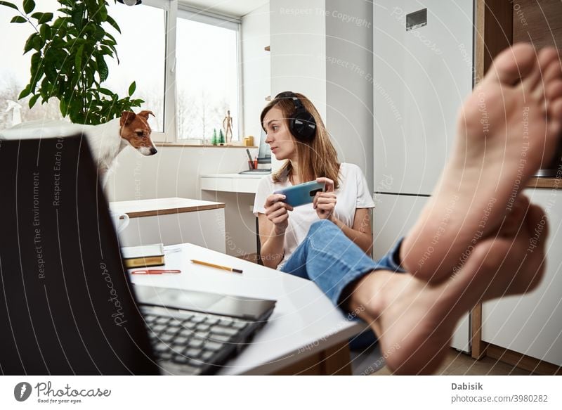 Woman listening online course in headphones, distance education. Freelancer sitting at workplace and procrastinating. Lazy and distracted employee at remote work