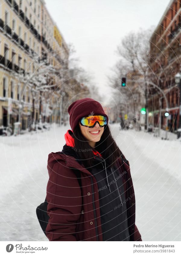 Woman with ski goggles in the middle of a snowy road in Madrid freedom young blue lifestyle sunglasses mirror person recreation mask winter top leisure activity