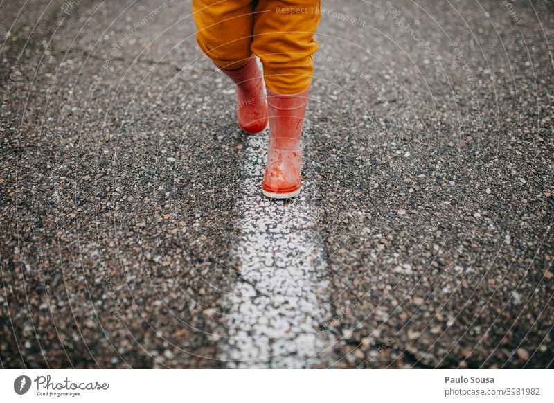 Close up child red rubber boots walking the line Red Rubber boots Line Walking Child Wet Infancy Water Human being Joy Exterior shot Rain Playing Colour photo