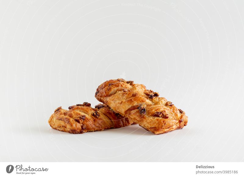 Two Danish maple pecan plaits pastry on a white background with copy space, close up baked baked pastry item bakery bread breakfast brown brunch closeup