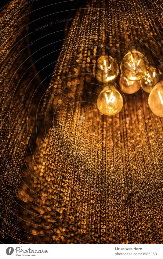An image of a luxurious brand of custom-made lighting fixtures. Light bulbs are shining bright and being surrounded by minimalistic chains. This chandelier is a perfect interior detail and the brightest one when it’s on.