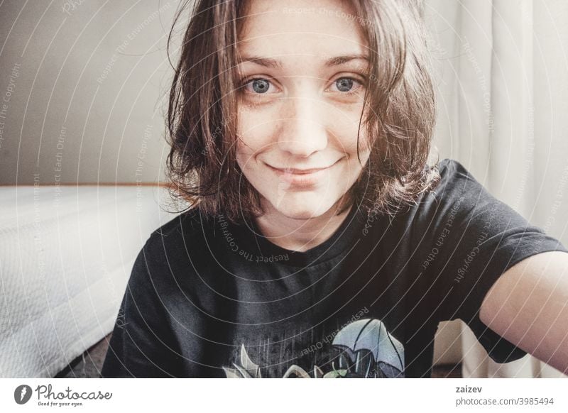 girl with short hair and blue eyes takes a selfie people female one person indoor teen 20s 30s medium copy space center landscape horizontal color eye contact