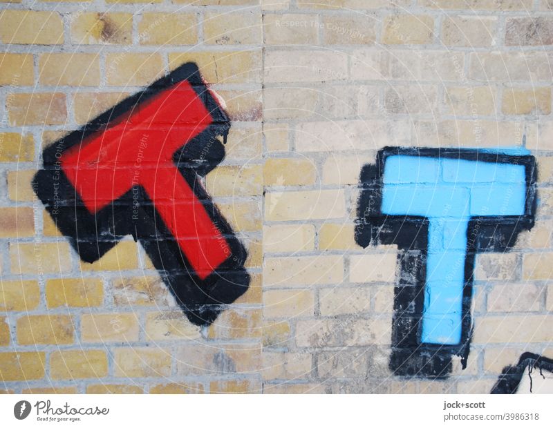 red and blue letter T sprayed on a wall brick wall Street art Capital letter Spray Creativity Red Blue Bordered Subculture black border Berlin Detail Typography