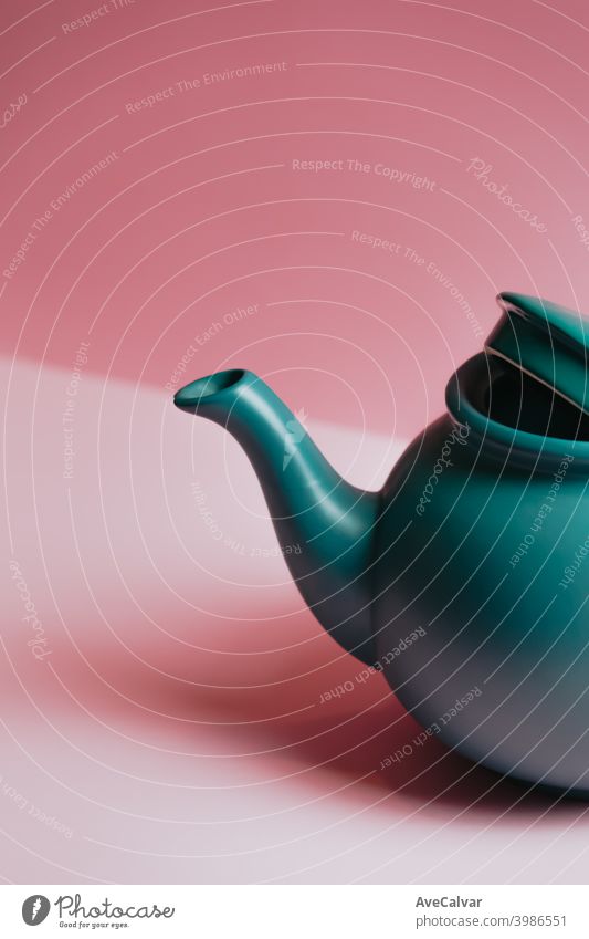A minimalistic close up of a blue teapot over a pastel pink background conceptual copy-space marketing sparse graphic luxury idea temptation tranquility indoors