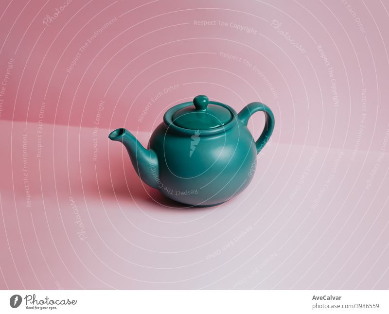 A minimalistic blue teapot over a pastel pink background with copy space conceptual copy-space marketing sparse graphic luxury idea temptation tranquility