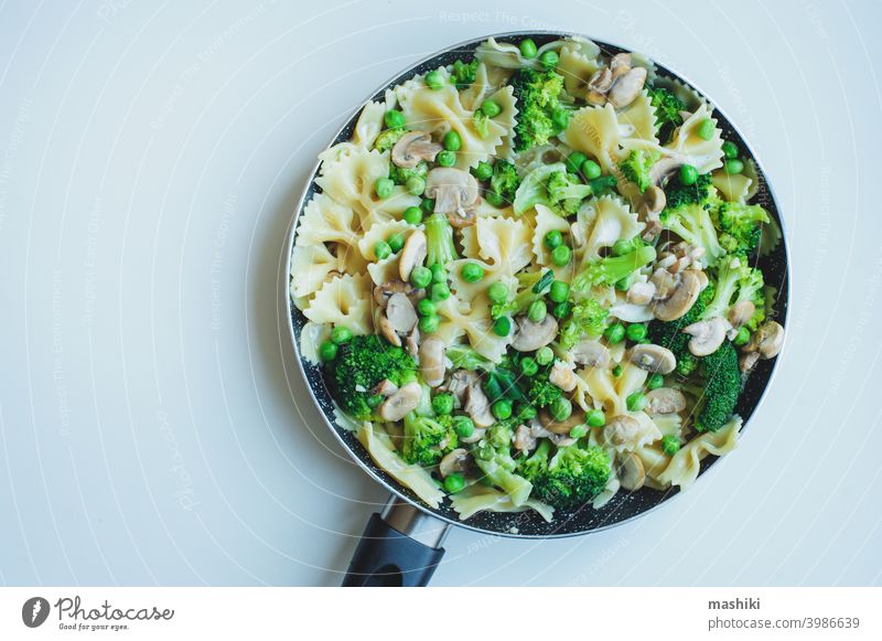 pan with cooked tasty italian vegetarian pasta with broccoli, green beans, mushrooms in creamy sauce. Tasty lunch or dinner food vegetable meal plate healthy