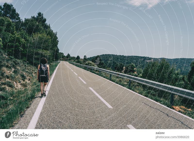 girl walking along the edge of a road la febró prades catalonia spain outdoor medium copy space color people female one person 20s 30s center right horizontal