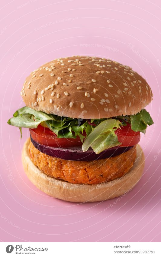 Chickpea burger with lettuce, tomato and onion on pink background alternative bread chickpea diet food fresh healthy ingredient lambs lettuce lunch nutrition
