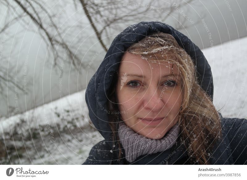 Young woman in snowfall with hood (self-portrait) Athletic Movement Relaxation Woman Cold Winter snowflakes eyes Nose Mouth long hairs Blonde blue jacket