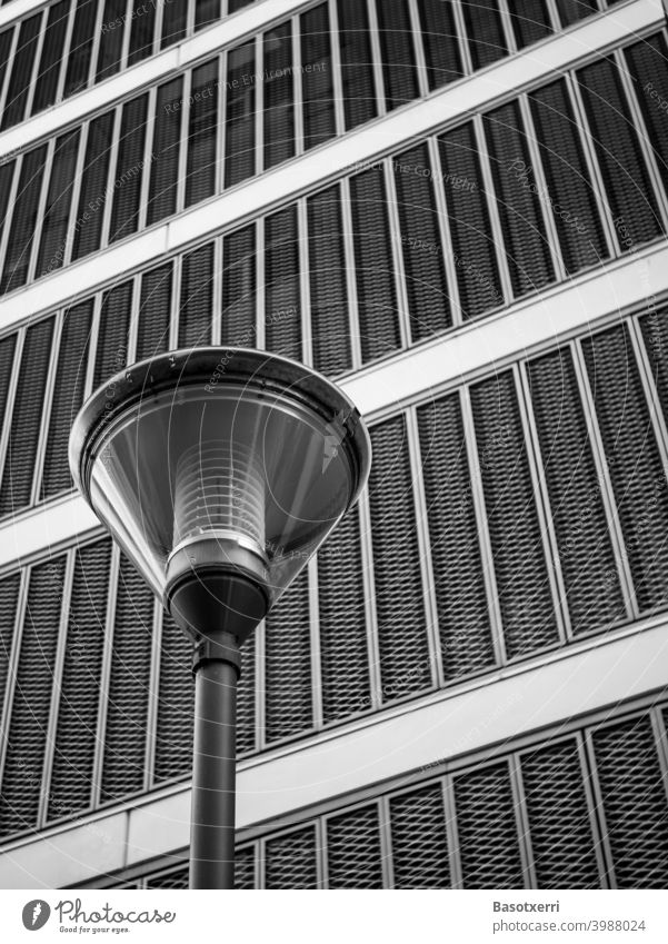 Modern street lamp in front of modern residential building with hinged metal facade as black and white photo Building Lantern Street lighting streetlamp