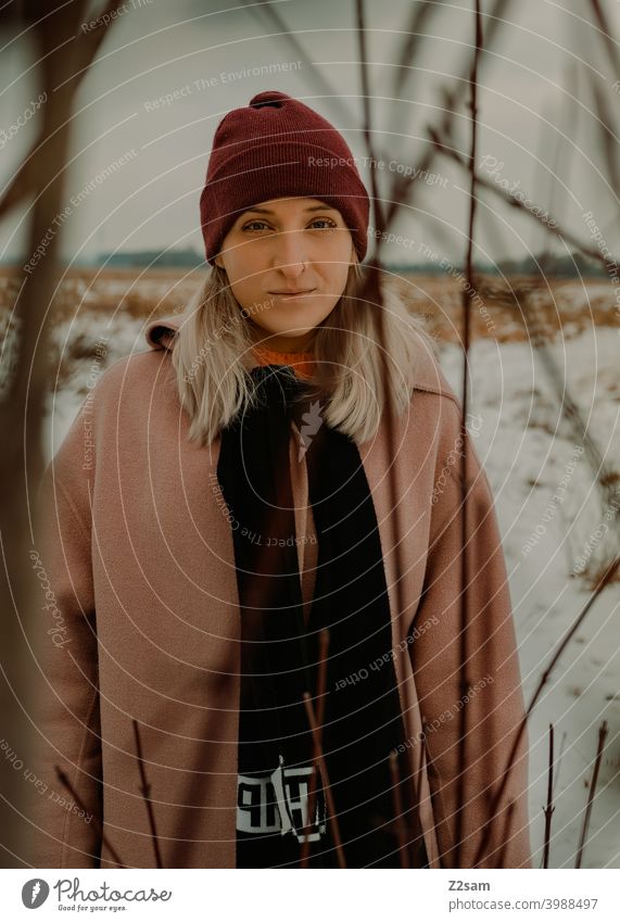 Portrait of a fashionably dressed woman in winter landscape Winter wonderland Woman Young woman Coat To go for a walk Snow Sun Light Nature Landscape Scarf Cap