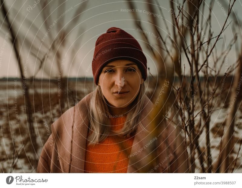 Portrait of a fashionably dressed woman in winter landscape Winter wonderland Woman Young woman Coat To go for a walk Snow Sun Light Nature Landscape Scarf Cap