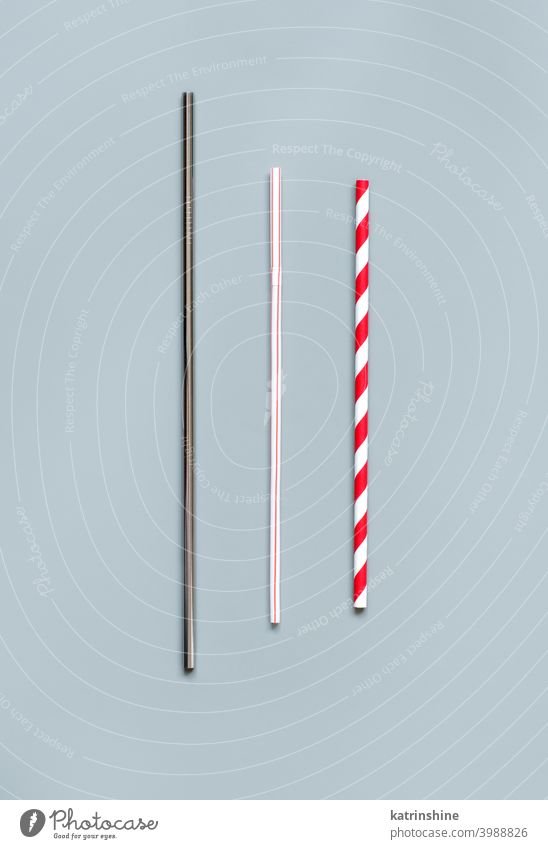 Modern reusable steel and paper drinking straws as alternative replacement for plastic drinking straw disposable grey background top view copy space