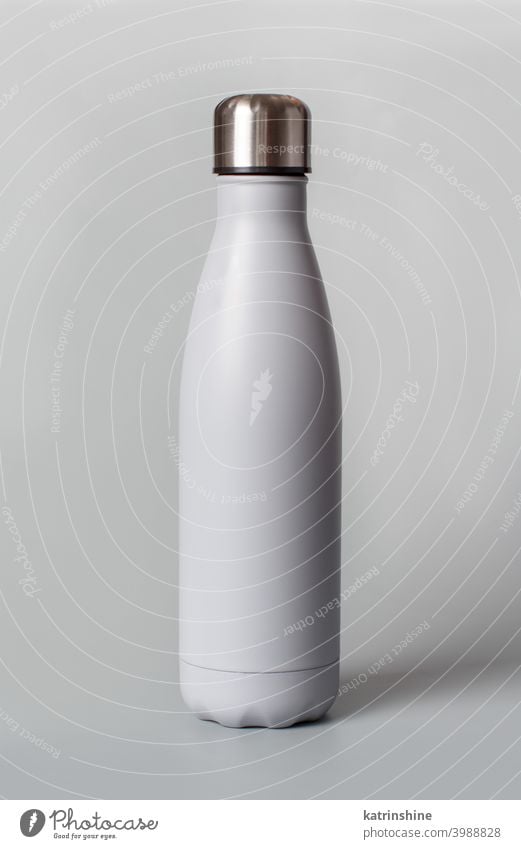 Grey reusable bottle on grey background monochrome mockup insulated ecologic water steel thermo aluminum blank close up concept copy space negative space