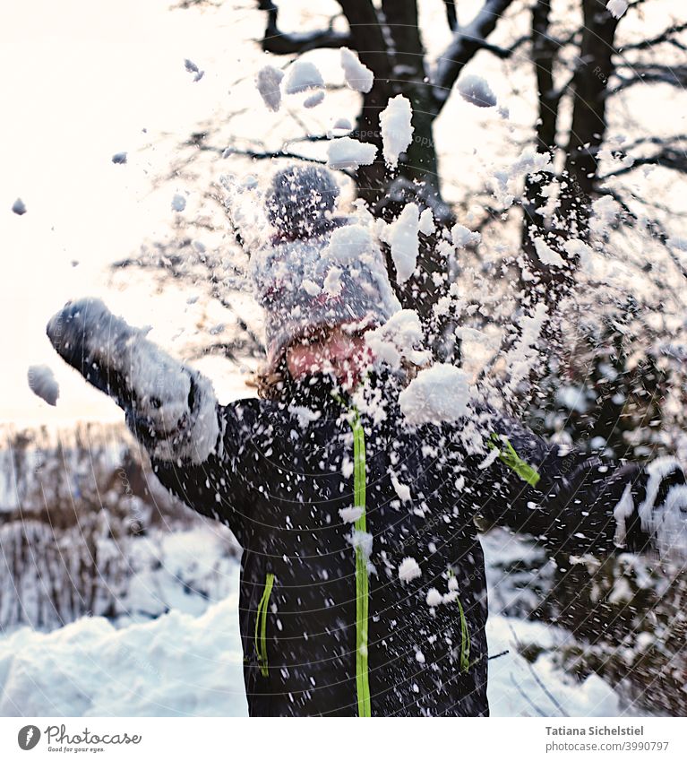 Girl throws snow in the air, frontal shot with motion blur Snow Winter Snowball Throw Joy White Cold Playing Exterior shot Action Child
