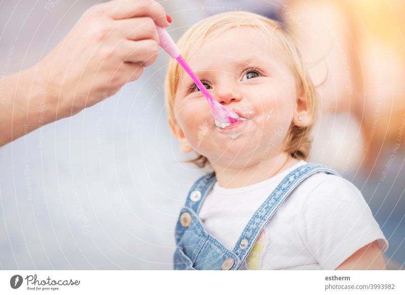 Baby eating outdoor active affectionate baby caucasian cheerful childhood contentment cute dairy educate expression family fathers feed fun growth happiness