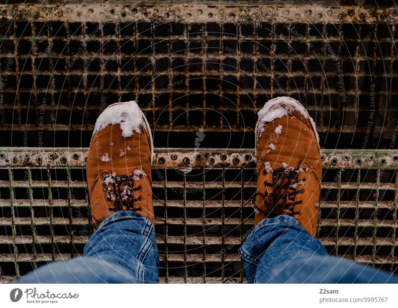Winter boots with snow on stairs Winter walk Boots Snow Legs feet winter shoes Buckskin Leather Brown jeans Blue Stairs men's shoes Man Bird's-eye view Fashion