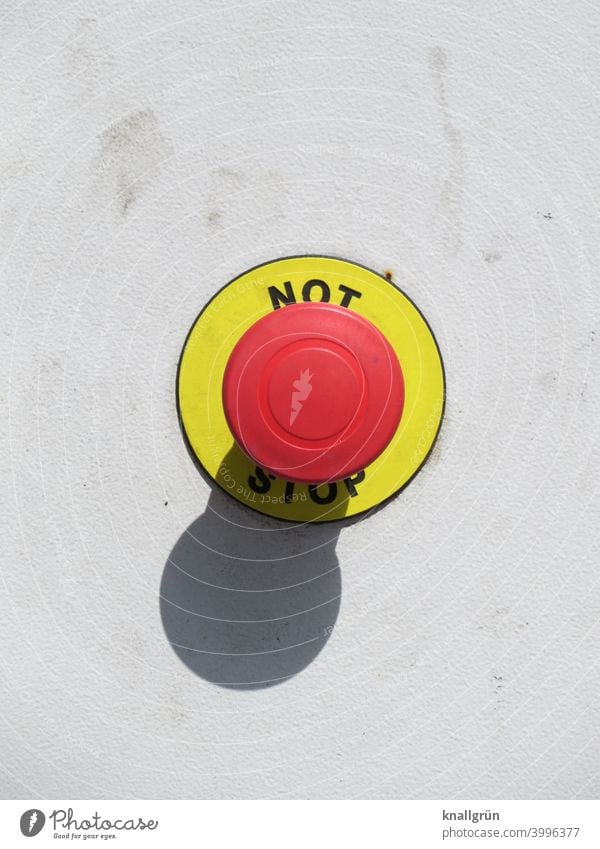 Emergency stop button in signal colours Signal alarm button Safety Exterior shot Light and shadow Symbols and metaphors Caution Round Pushing Red Yellow White