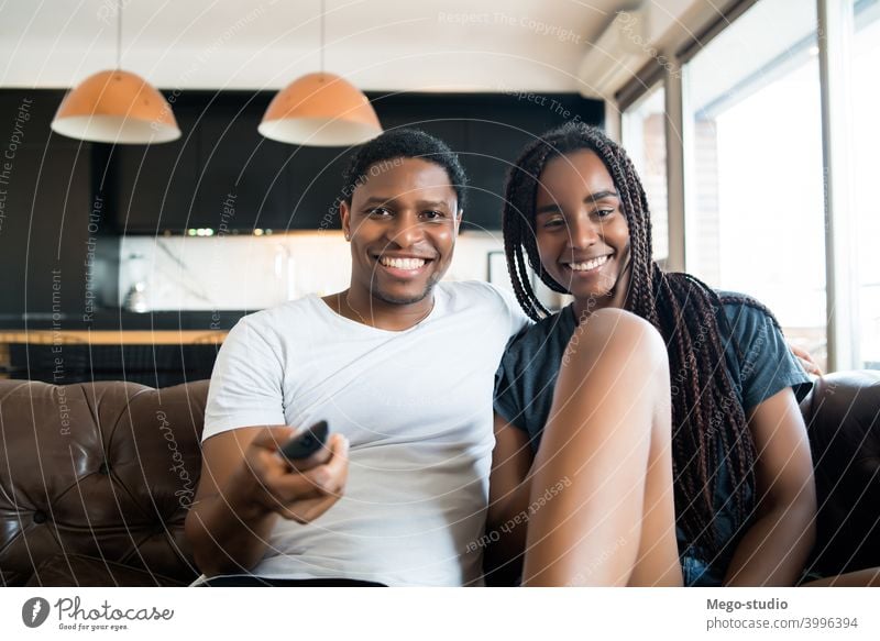 Couple spending time together while staying at home. young couple couch tv indoors lifestyle quarantine sofa movies series technology enjoying sitting woman two
