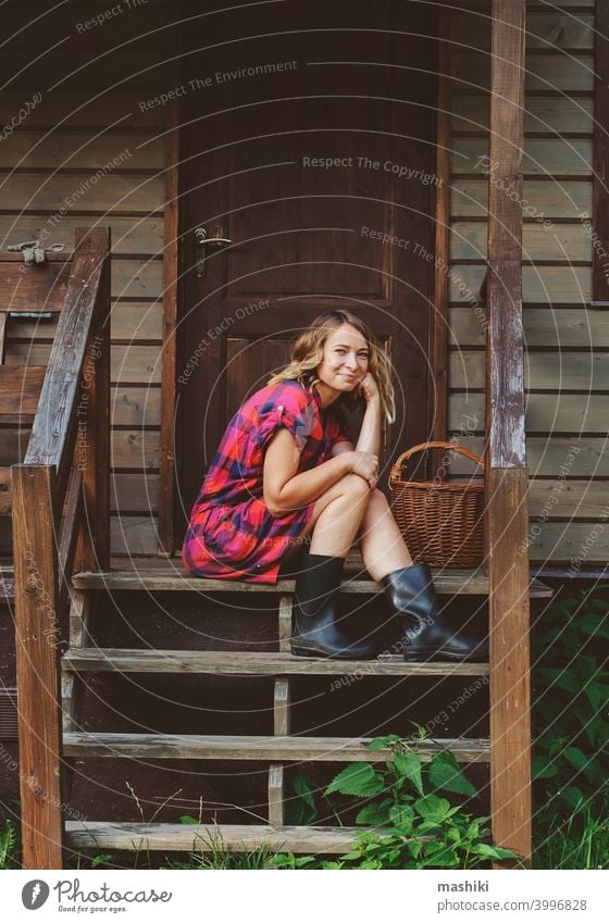 happy woman sitting on porch of her wooden country house. Rural living, running away to nature, ecology concept summer adult female home casual countryside girl