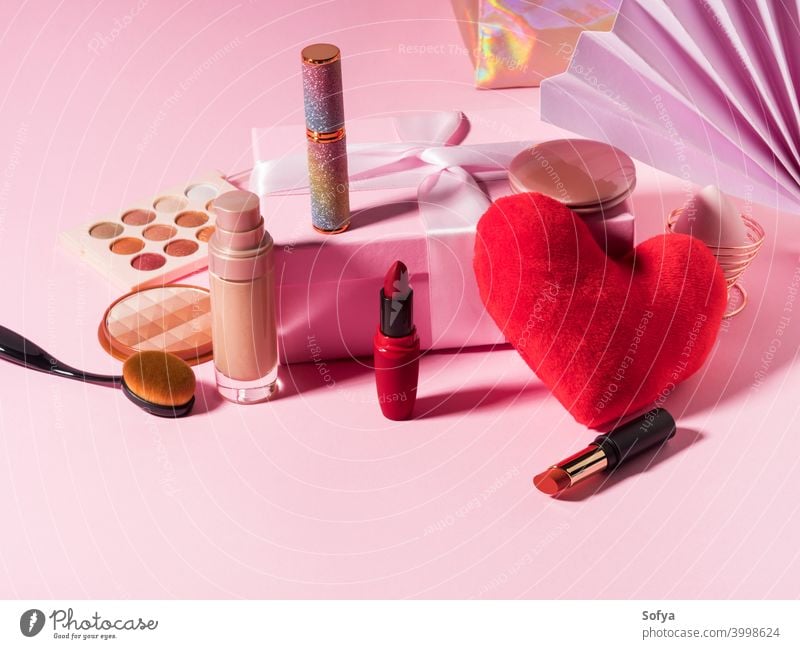 Cosmetics beauty background with red heart on pink makeup products cosmetic lipstick valentine foundation make up brush display shadow fashion geometry set day