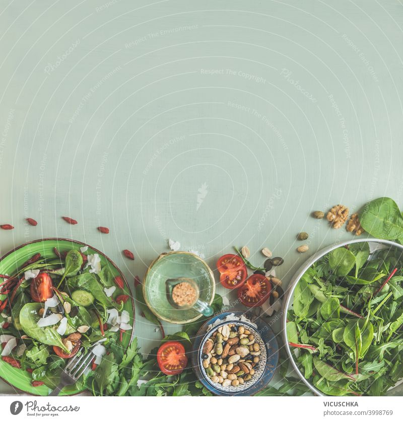 Green salad with nuts in plates on light green background with ingredients. Healthy lunch. Top view. Frame. Copy space topping healthy top view frame copy space