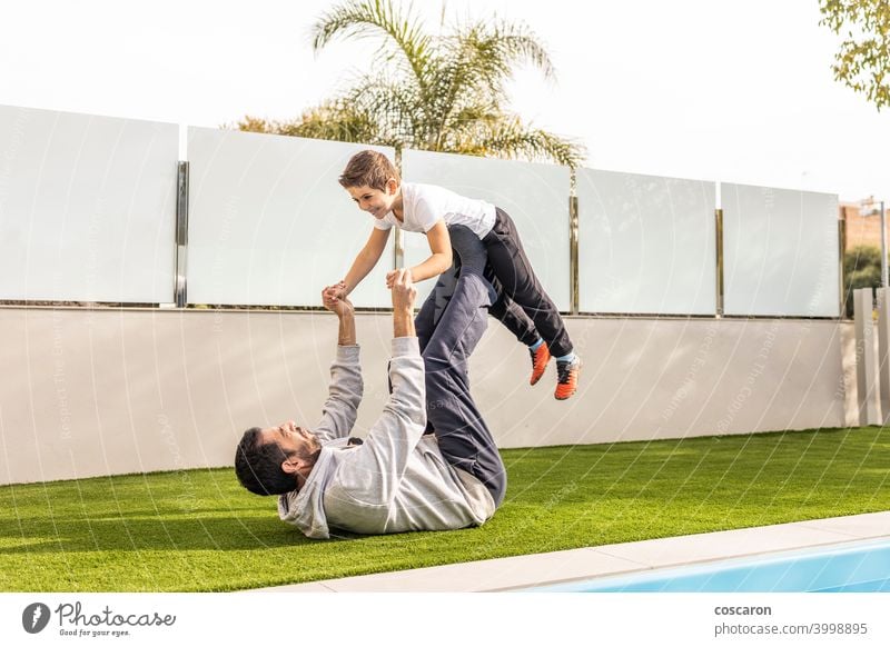 Father and son doing exercise in their home garden active activity balance balancing boy carefree carry cheerful child childhood children cute day family father