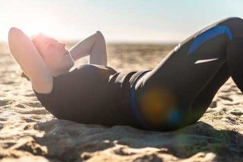 Middle aged woman doing exercise on the beach abs active adult alone athlete attractive balance beautiful blue body energy female fit fitness girl healthy
