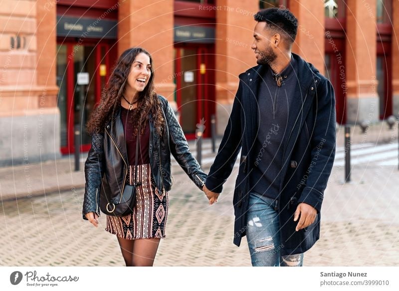 Interracial Couple Holding Hands street couple looking at each other interracial couple black afro african american diversity multi-racial black man ethnic