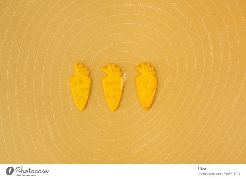 Three carrots on yellow background Carrot Yellow Orange Cookie Easter Vitamin B good for the eyes three