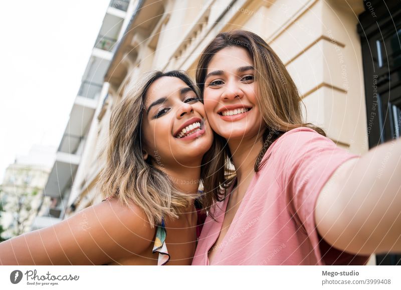 Two friends taking a selfie outdoors. young two woman city friendship laughing portrait fun tourism travel enjoyment smiling looking cute leisure media social