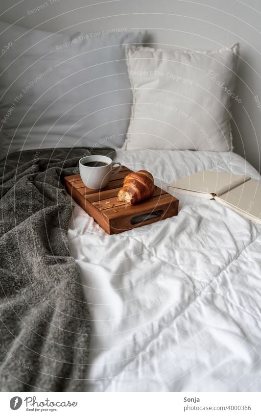 Breakfast in bed with a cup of coffee and a croissant Bed Coffee Croissant hygge Lifestyle Morning Cup at home Bedclothes Cushion Book serving tray Wood Weekend