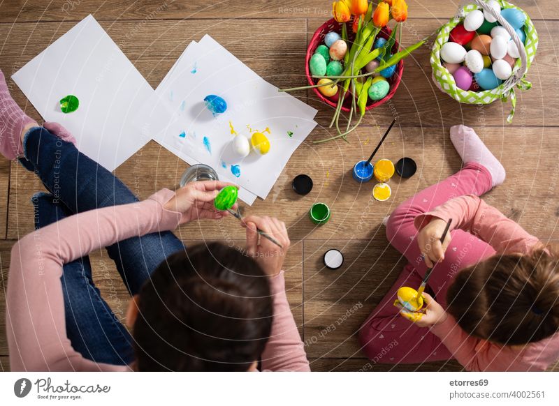 A mother and her daughter painting Easter eggs baby basket blonde bunny celebration childhood colors creativity decoration easter family girl happiness holiday