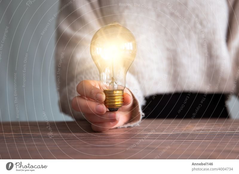 Female hand holding a shining light bulb, Great idea, innovation and inspiration, business concept background energy lamp bright electricity creativity