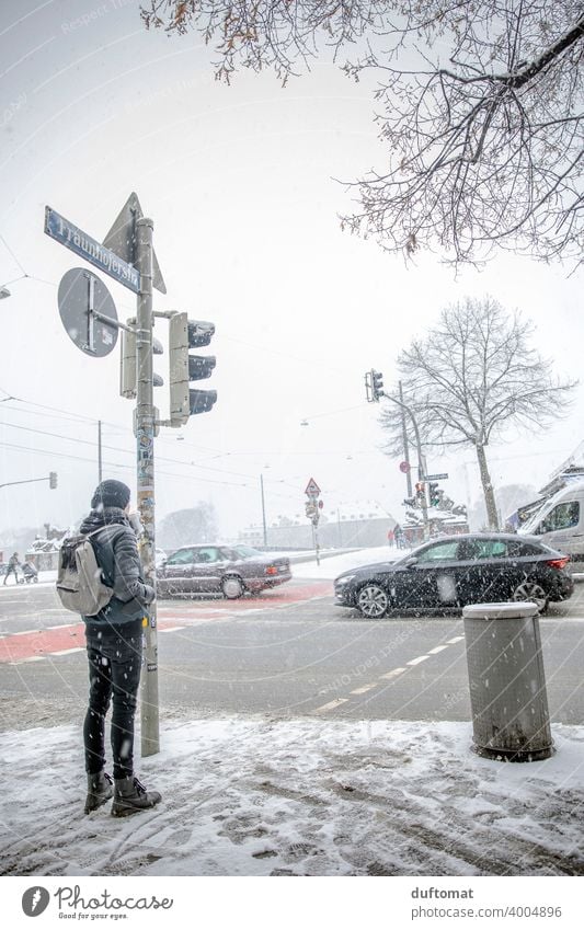 Man waits in snowstorm at busy intersection Winter Snow White cross urban Town Freeze Ice Cold Snowfall Snowflake Traffic light Transport Exterior shot Frost
