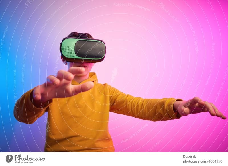 Boy with virtual reality glasses on colorful background. Future technology, VR concept vr headset boy helmet device game future video experience wearable