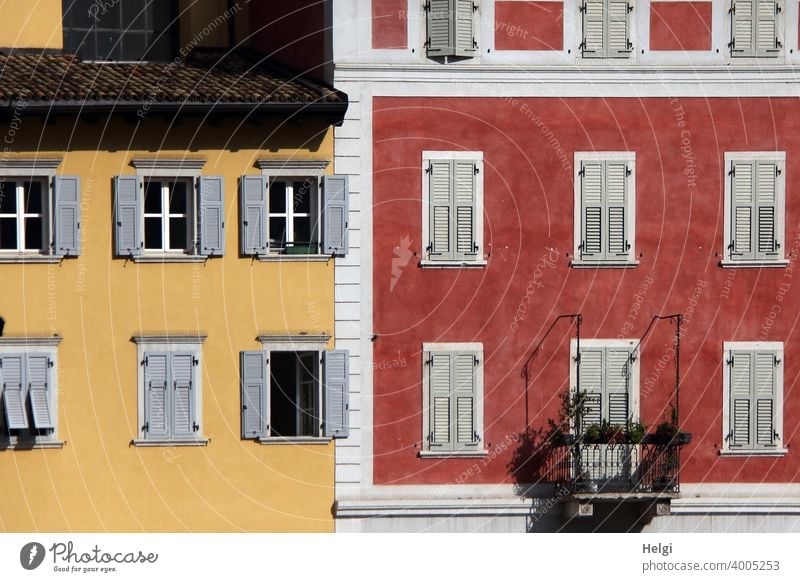 Facades,painted red and yellow with white and grey windows and shutters, a balcony House (Residential Structure) Building Window Balcony colored Shutter