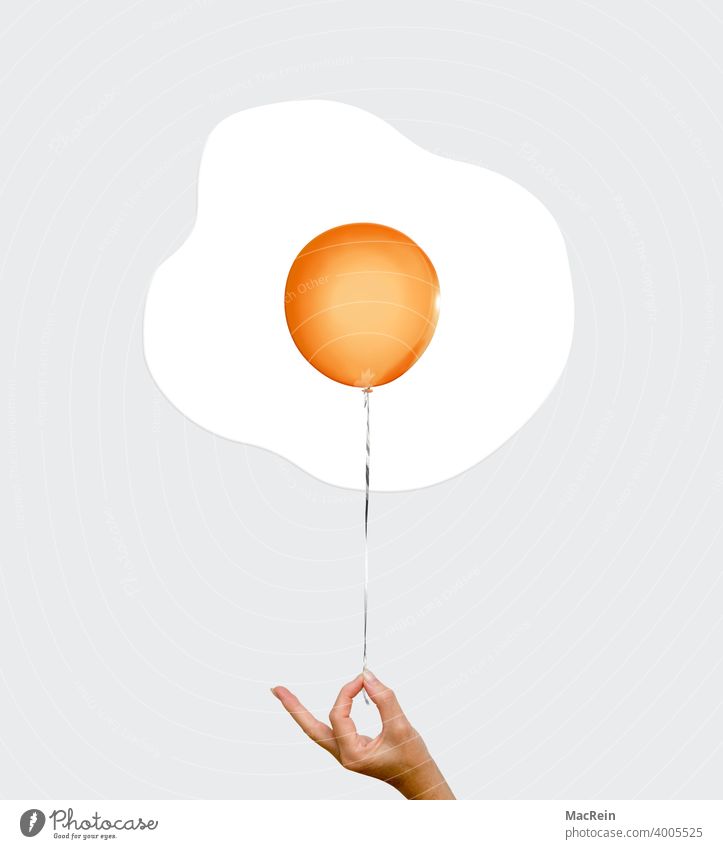 fried egg balloon Egg Yolk yolk thread color photograph To hold on Fingers Hand stop Orange Fried egg sunny-side up nobody Copy Space symbol picture