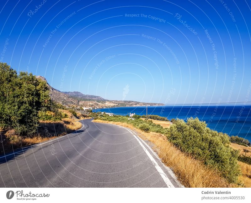 Coastline and a curving road in Keratokampos, Crete asphalt bay beach cloud coast ecoregion freeway grass green highway horizon island lake landscape nature