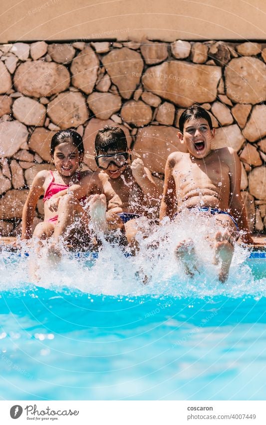 Children splashing water at the edge of the pool activity blue boy brother caucasian child childhood children cute day enjoy family friends fun goggle happiness