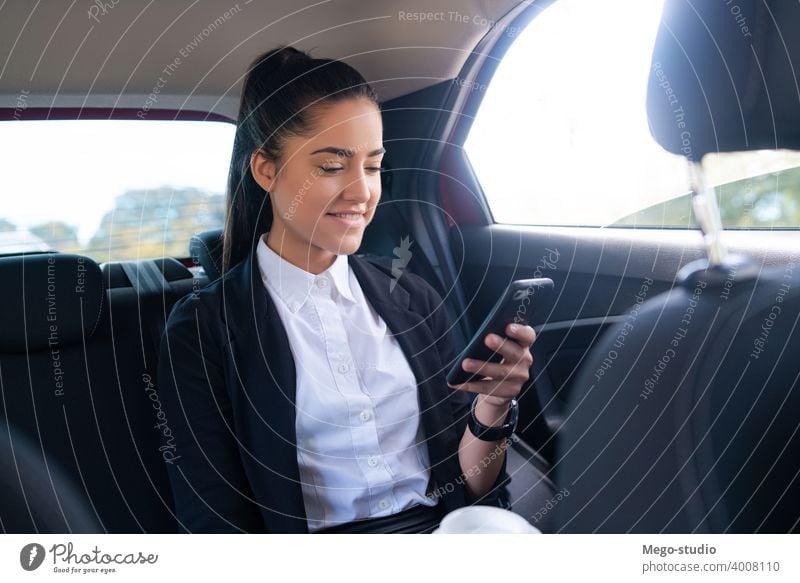 Businesswoman using mobile phone in car. businesswoman taxi transportation cab male portrait adult professional auto going to work wireless entrepreneur elegant