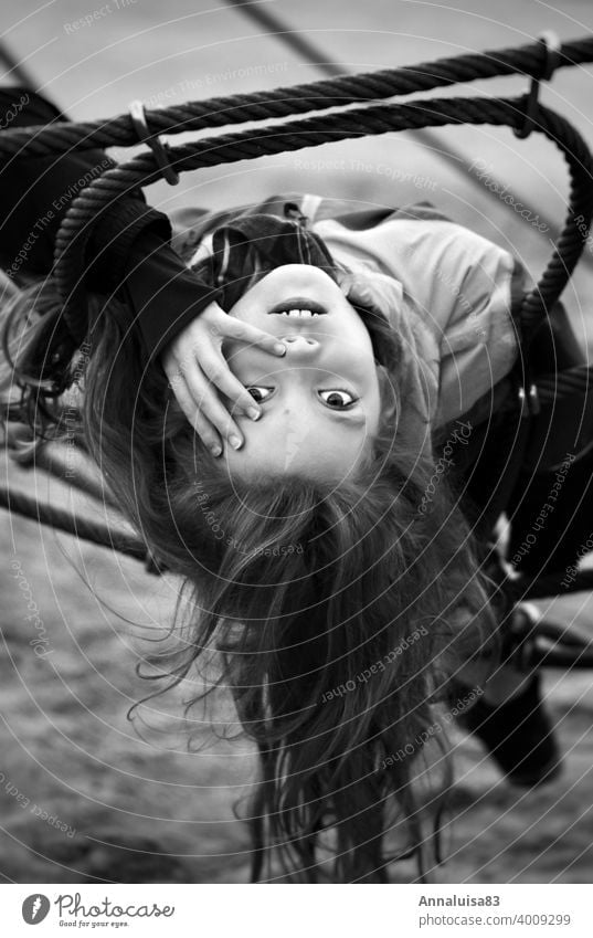 I can't think of a name. Girl Playing Playground Climbing Black & white photo portrait Child Infancy Youth (Young adults) go out peep Hang Cold Winter Face