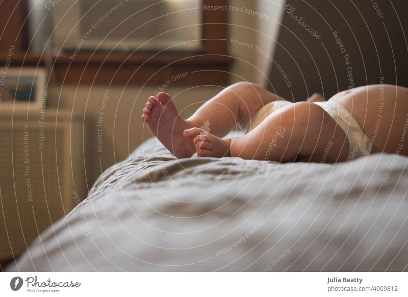 Young baby's feet and legs; child laying on parent's bed foot newborn love small toes care human kid childhood little family barefoot infant skin boy cute