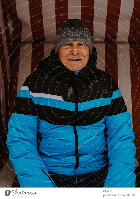 Portrait of a sporty pensioner Pensioners Athletic Man age down jacket Winter chill Cap Laughter kind naturally portrait out warm colors sincerely free time