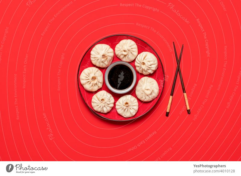 Baozi dumplings on a red plate with soy sauce. Steamed bao dumplings, flat lay asian baozi bun chinese chinese food chopsticks colored background colorful