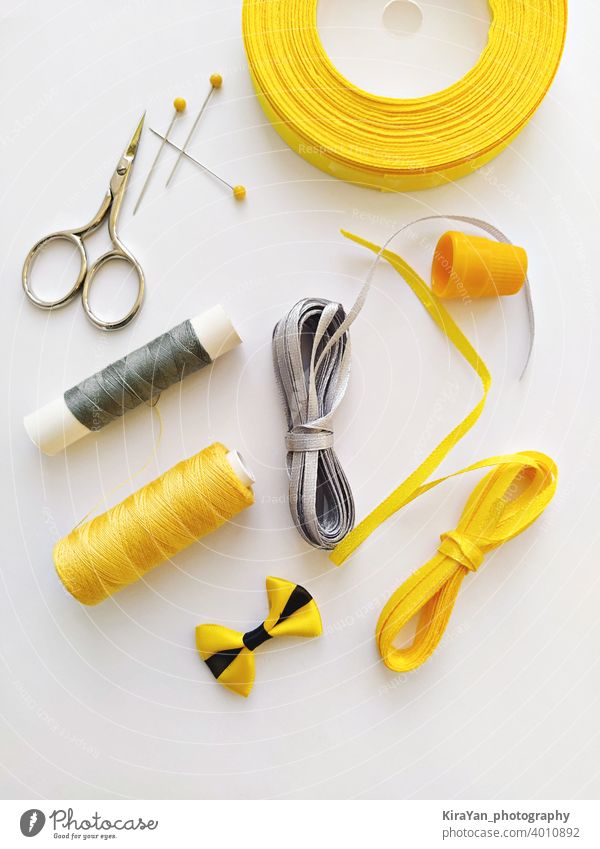 Flat lay with sewing kit and sewing accessories in trend Illuminating yellow and ultimate gray ribbon colors bobbin checkered concept craft diy dressmaker