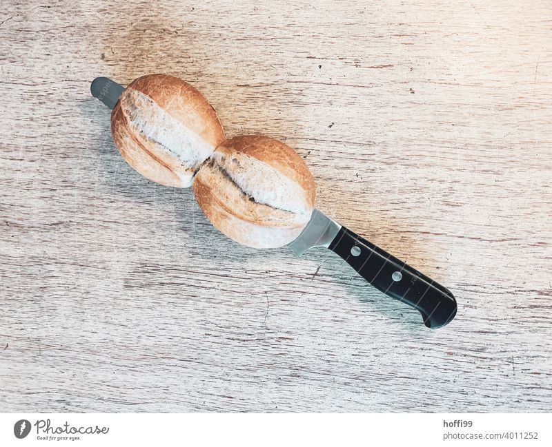 two rolls with knife in the cut Roll Breakfast Knives Delicious Organic produce Nutrition Bread Minimalistic Baked goods bread knife Dough Fresh