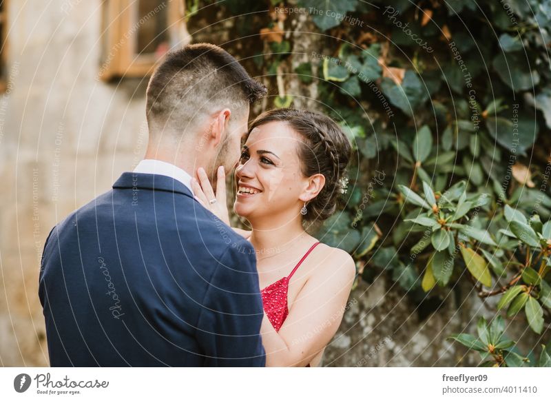 Portrait of an elegant young couple prom kiss 20s dress suit red first time event caucasian luxury luxurious castle ancient tuxedo vegetation elegancy romance