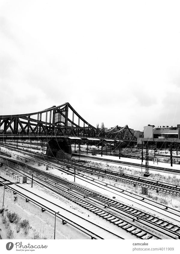Bridge at the station with rail network in the snow Tracks Railroad system urban Town Winter Train Black & white photo Portrait format Gray scale value Light